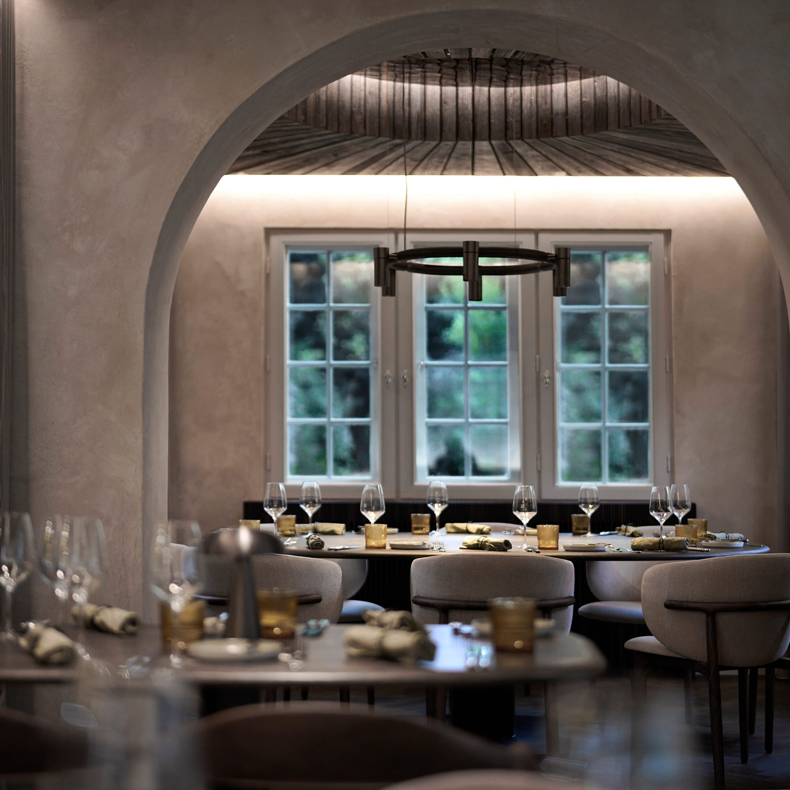 Eleganter Restaurantbereich mit runden Tischen, gedeckt mit Gl&auml;sern und Geschirr, umrahmt von einem Bogen.