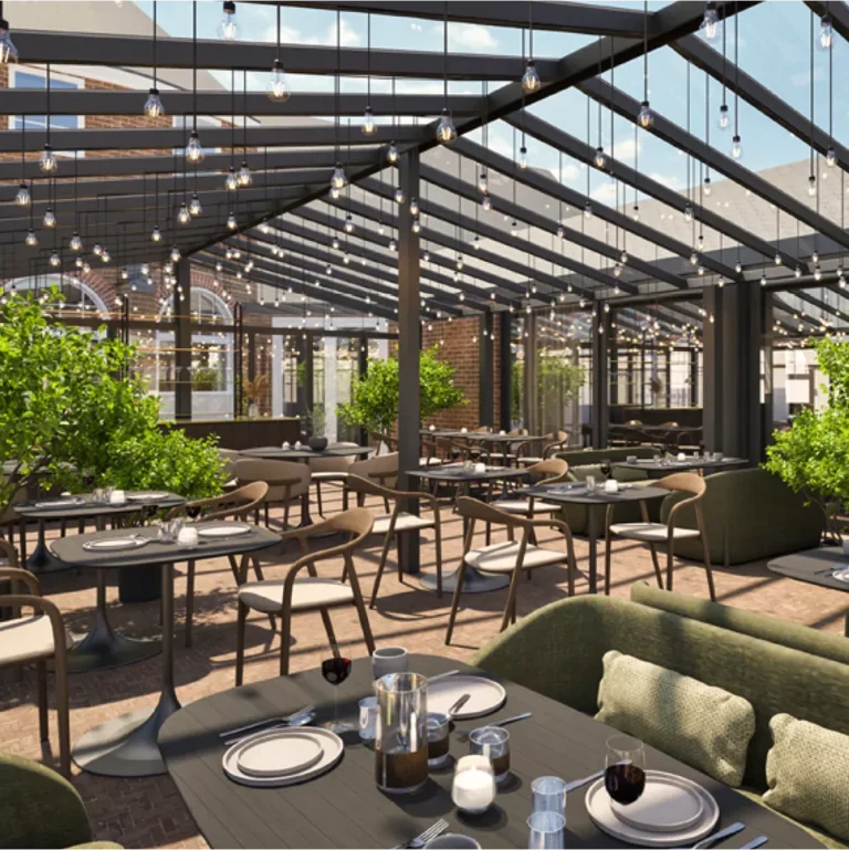 Moderne Restaurantterrasse mit eleganten Tischen, St&uuml;hlen und gr&uuml;nen Pflanzen, beleuchtet von h&auml;ngenden Lichtern.